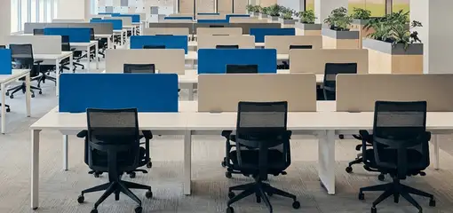 Modern open-plan office space featuring clean workstations, ergonomic chairs, and sanitized carpets provided by professional office cleaning services in Orlando, FL.